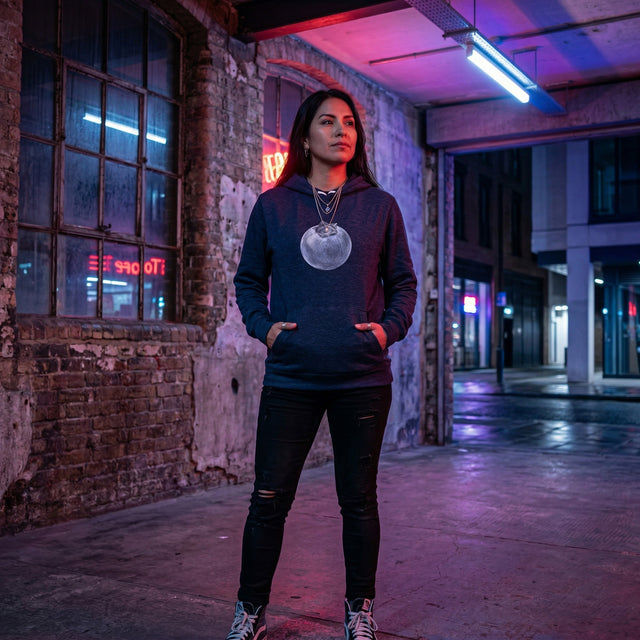 Person wearing a hoodie with a blueberry design in an urban setting with neon lights.