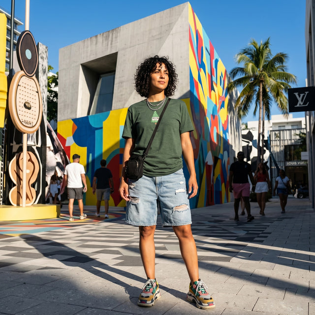 Person standing in front of a colorful mural on a city street