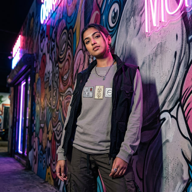 Person standing in front of a colorful graffiti wall at night
