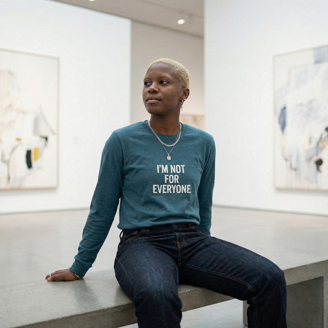 Ichinichi unisex long sleeve t-shirt in heather deep teal with 'I'm Not For Everyone' text, modeled in a minimalist modern art gallery.