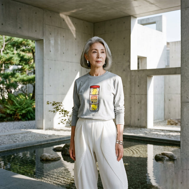 Woman standing in a modern architectural setting with concrete walls and a pond.