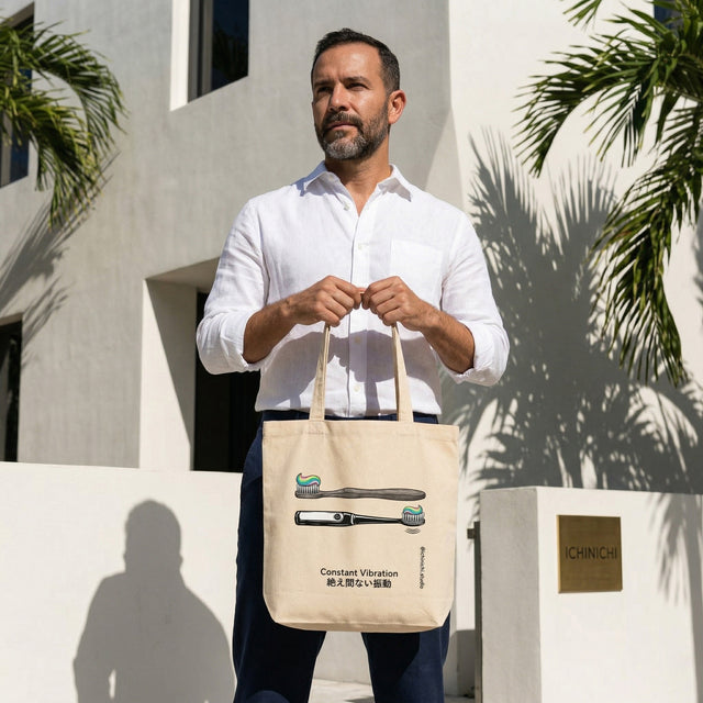 Man holding a beige tote bag with graphic design, standing outdoors against a light-colored building.