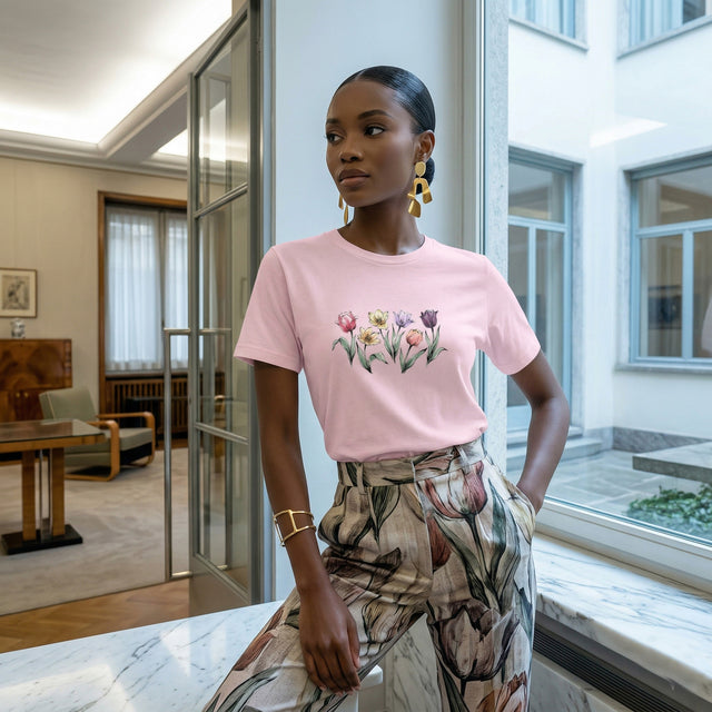 A 20s Nigerian female model in a high-fashion editorial pose, wearing the light pink ICHINICHI tulip graphic tee paired with botanical trousers within the refined architectural setting of Villa Necchi Campiglio, Milan, under clean, precise gallery lighting.