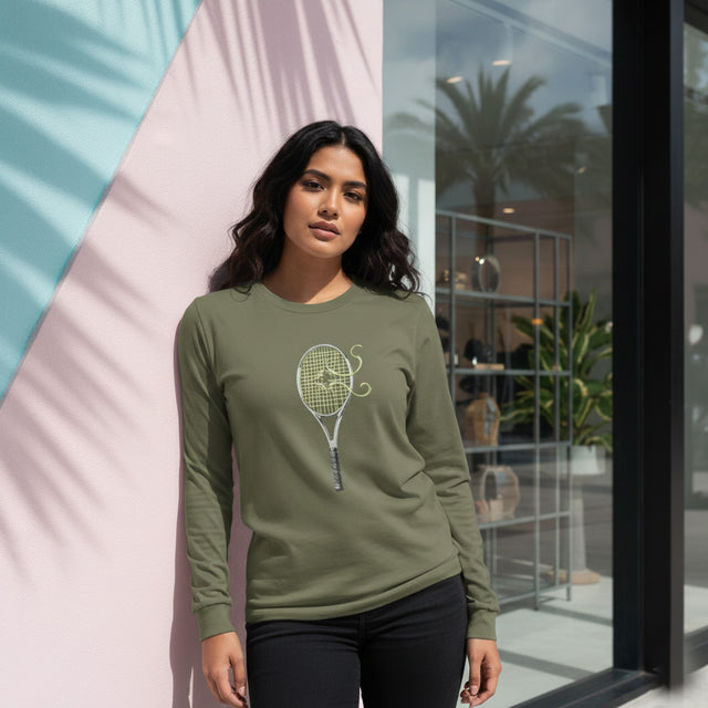 Woman wearing a green long-sleeve shirt with a graphic design, standing indoors.