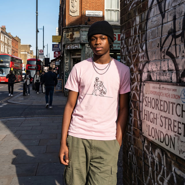 Person standing on a street corner in Shoreditch, London, wearing a pink t-shirt and green pants.