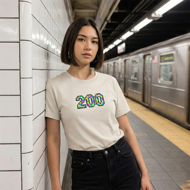 Person wearing a white t-shirt with '200' design in a subway station