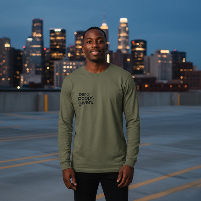 Man wearing a green long-sleeve shirt with 'zero poops given.' text, standing on a rooftop with city skyline in the background.