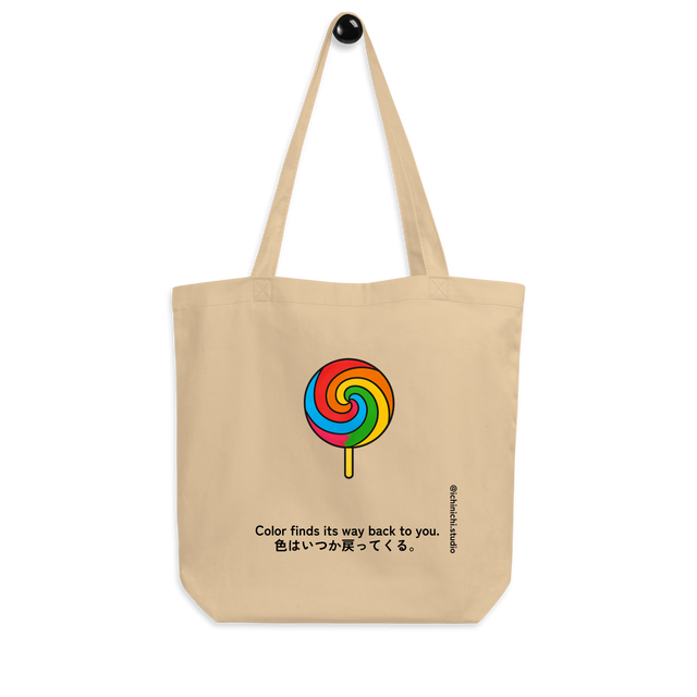 Minimal rainbow swirl lollipop illustration centered on a tote bag.
