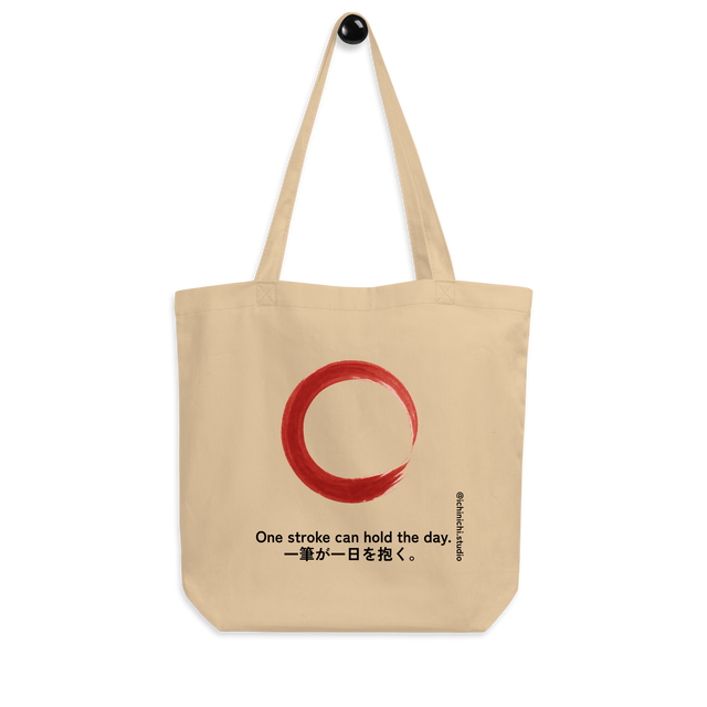 Minimal red brushstroke forming an imperfect rising circle on a tote bag design.