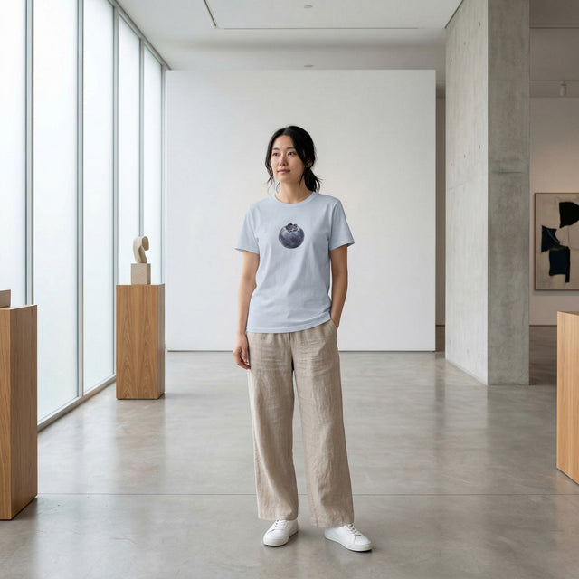 Person wearing a light blue t-shirt with a blueberry design in a modern indoor setting