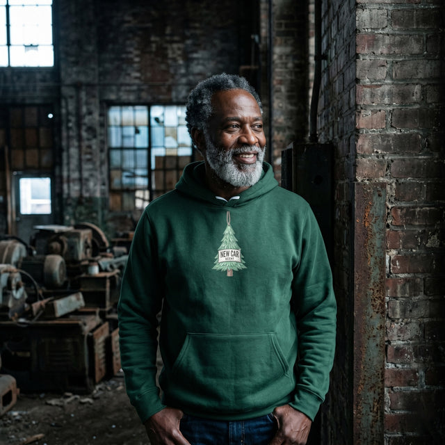 Man wearing a green hoodie with a logo in an industrial setting