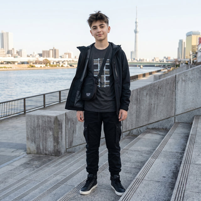 Person standing by a waterfront with a city skyline in the background