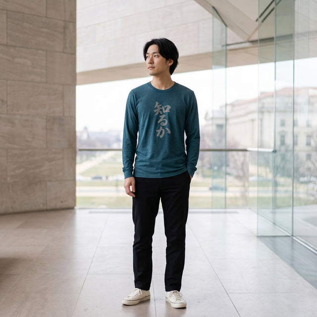 Man wearing a teal long-sleeve shirt with white text in an indoor setting
