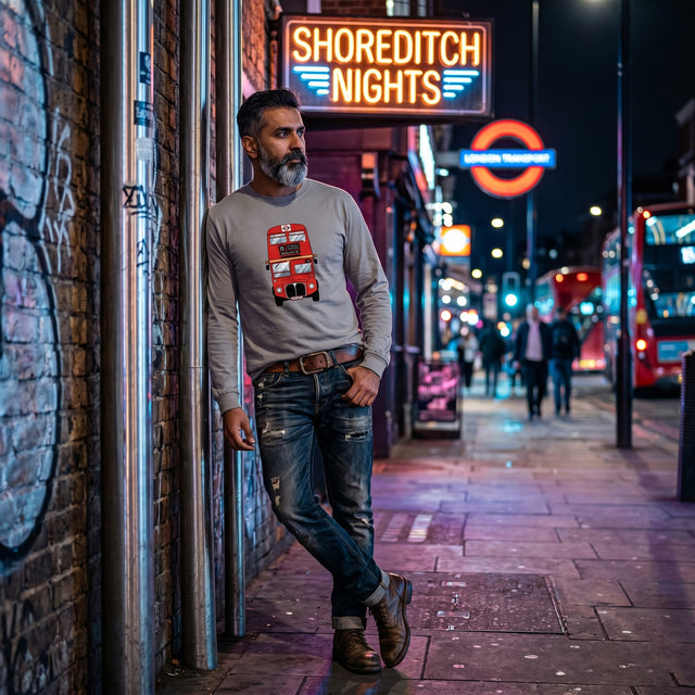 Man standing in a street with neon signs, including 'Shoreditch Nights', at night.
