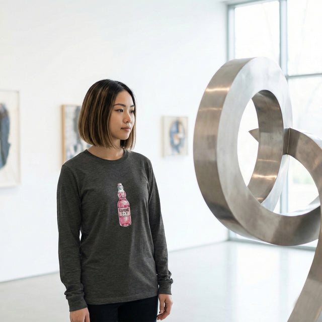 Person wearing a dark gray sweatshirt with a pink bottle graphic in an art gallery.