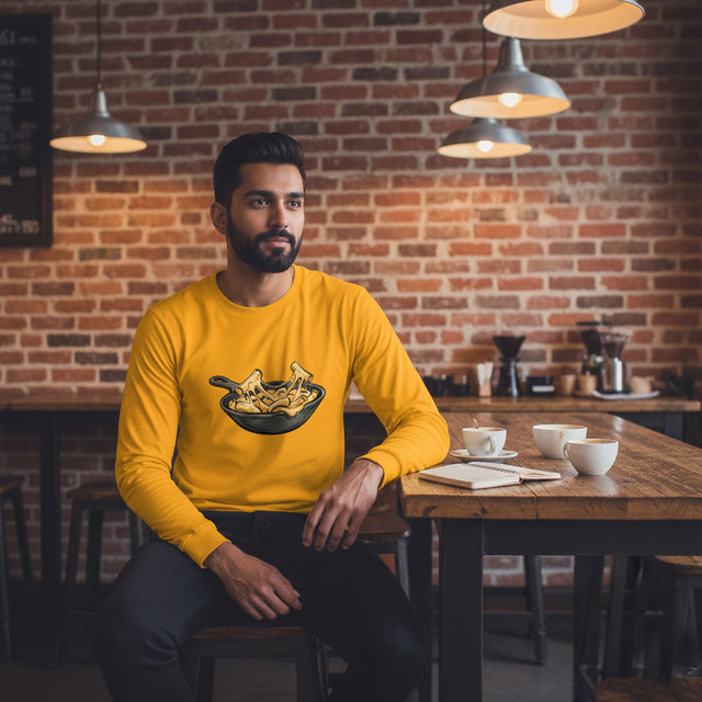 Man in a yellow sweatshirt sitting at a table in a cozy cafe with a brick wall background.