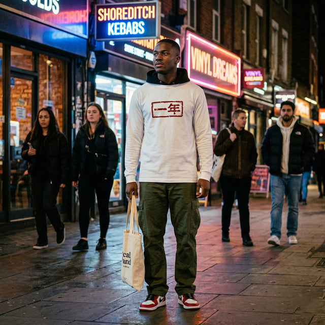 Man walking on a street at night with neon signs and people in the background