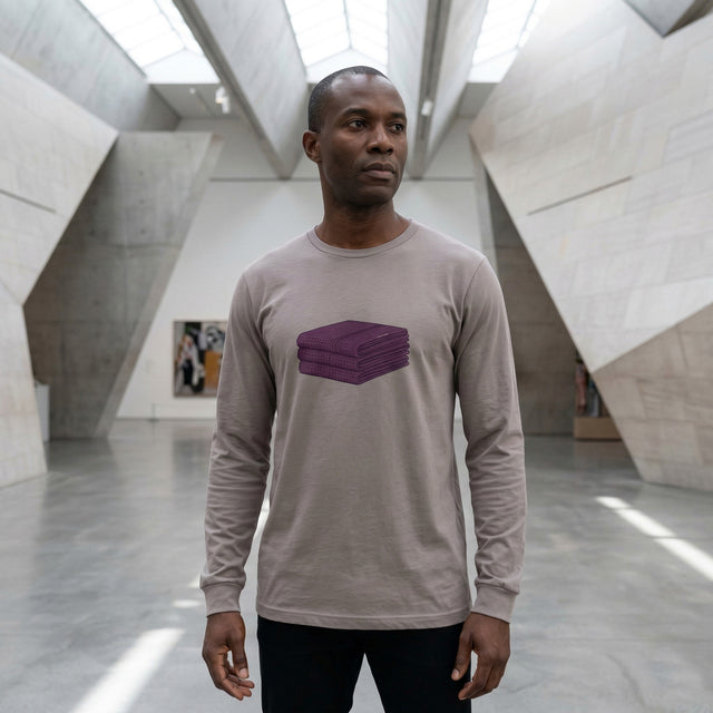Person wearing a long-sleeve shirt with a purple graphic in a modern architectural setting