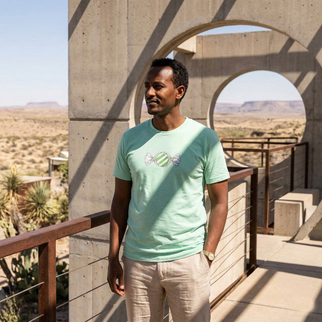 背景に砂漠の風景が描かれた薄緑色のTシャツを着た男性
