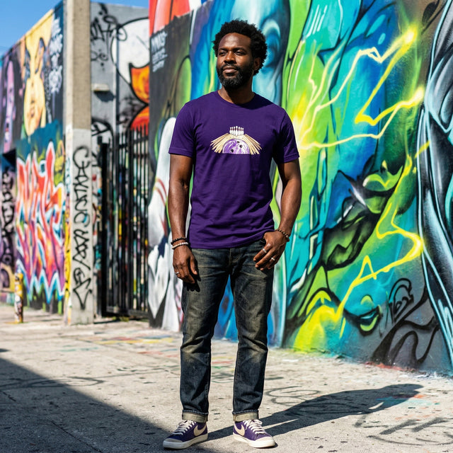 Man wearing a purple t-shirt with a graphic design standing in front of colorful graffiti art.