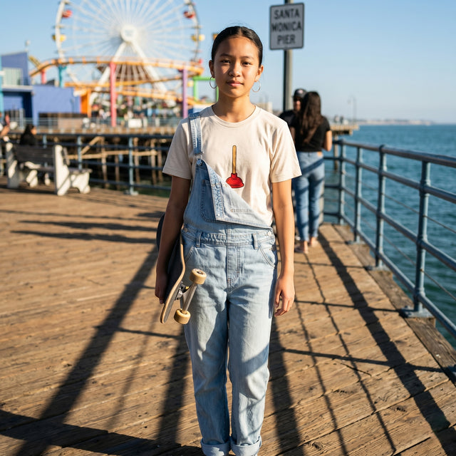 Person standing on a pier with a Ferris wheel and ocean view