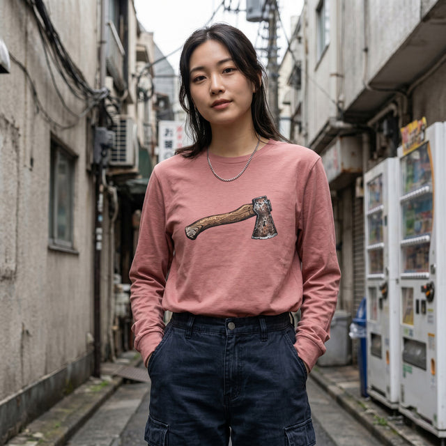 Woman wearing a pink sweatshirt with a graphic design in an urban alleyway.