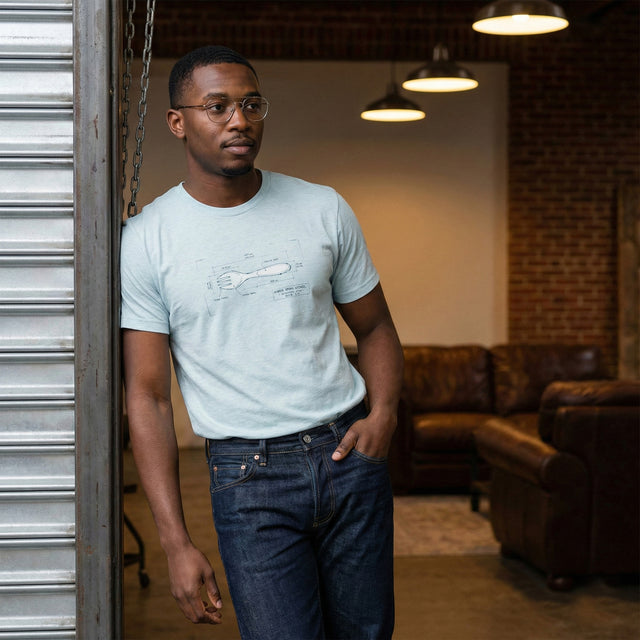 Unisex T-Shirt in Heather Prism Ice Blue featuring a technical blueprint graphic of a Hybrid Spork Utensil with dimension lines and industrial design text.