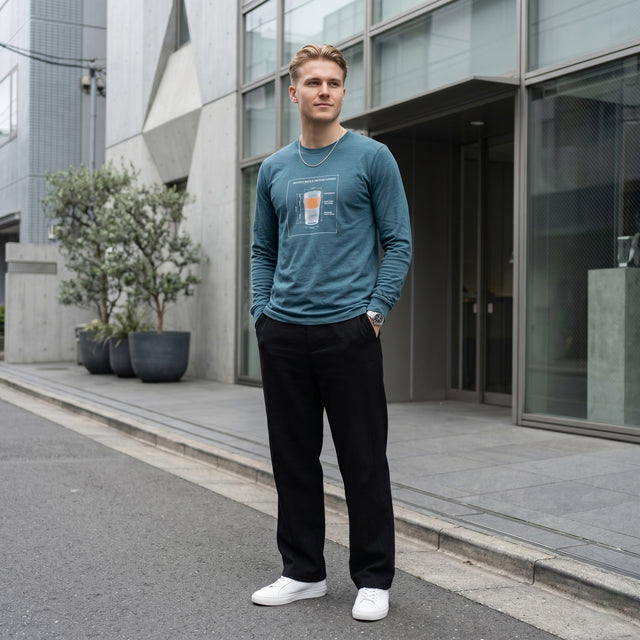 Man wearing a blue sweatshirt with a graphic design, standing on a street in an urban setting.