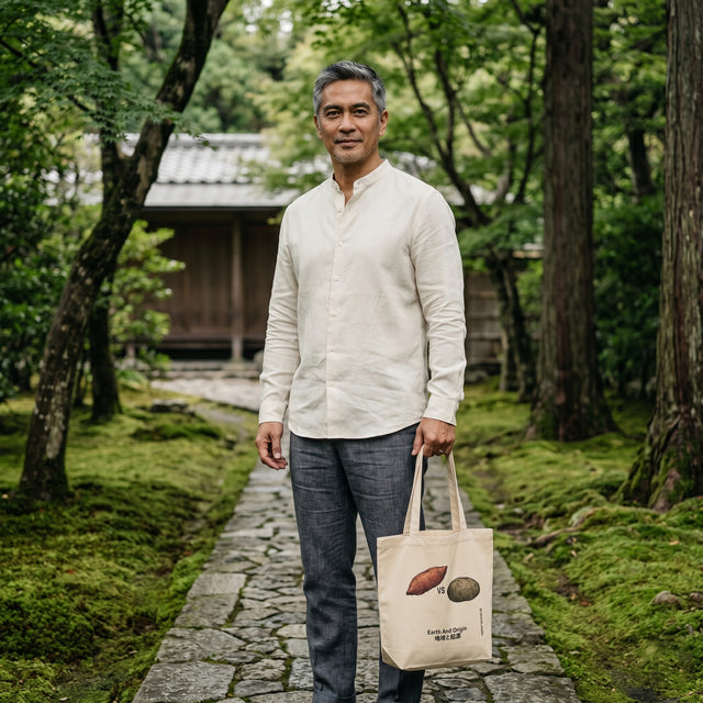 Man holding a tote bag with nature-themed design in a forest setting