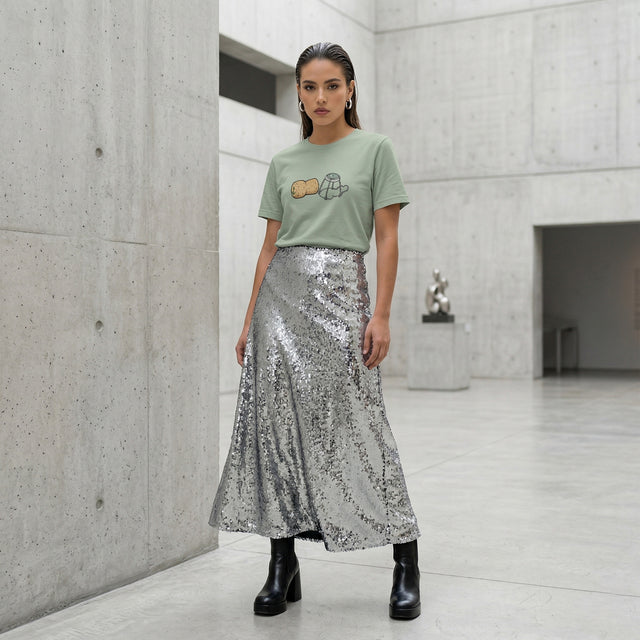 Woman wearing a green t-shirt and silver sequin skirt in a modern indoor setting