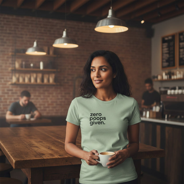 Woman in a coffee shop wearing a t-shirt with 'zero phones given' text, holding a cup.