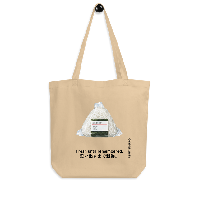 Minimalist Eco Tote Bag design featuring a wrapped onigiri with expiration date, price, and weight label.
