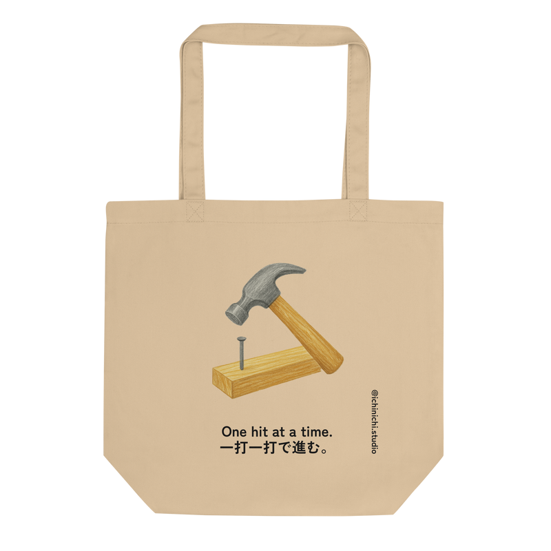 Minimalist Eco Tote Bag design featuring a hammer driving a nail into a 2x4 board.
