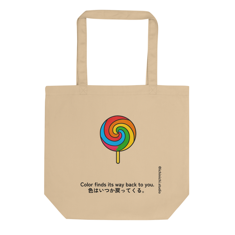 Minimal rainbow swirl lollipop illustration centered on a tote bag.
