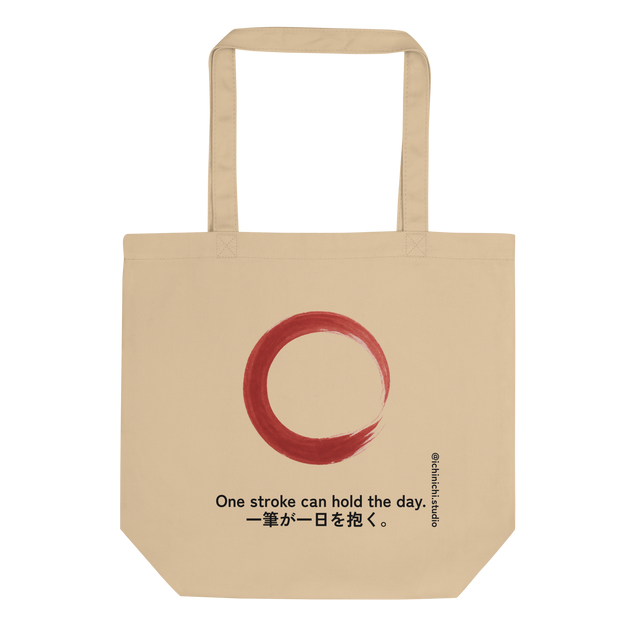 Minimal red brushstroke forming an imperfect rising circle on a tote bag design.
