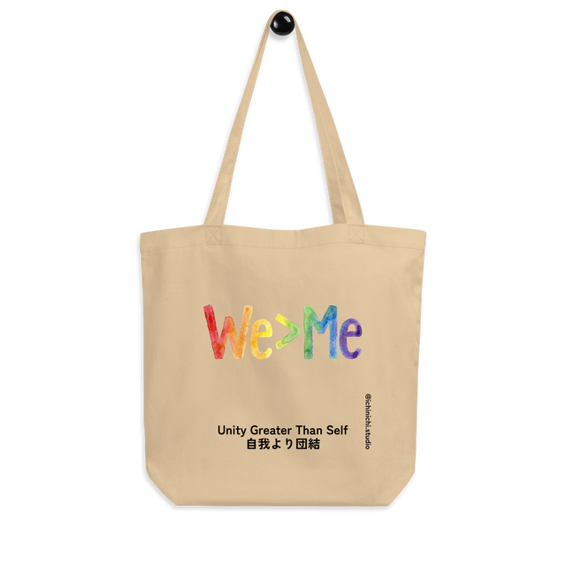 Eco Tote Bag featuring "We > Me" typography filled with a hand-drawn rainbow gradient.