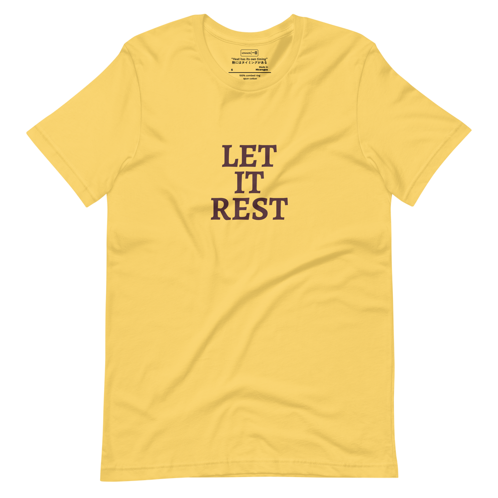 Text-based design with the words “Let It Rest” in bold serif on a yellow shirt
